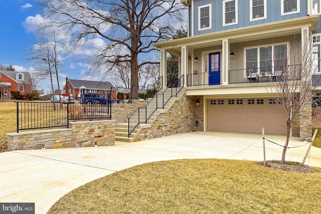 view of front of house featuring a garage, covered porch, and a front yard