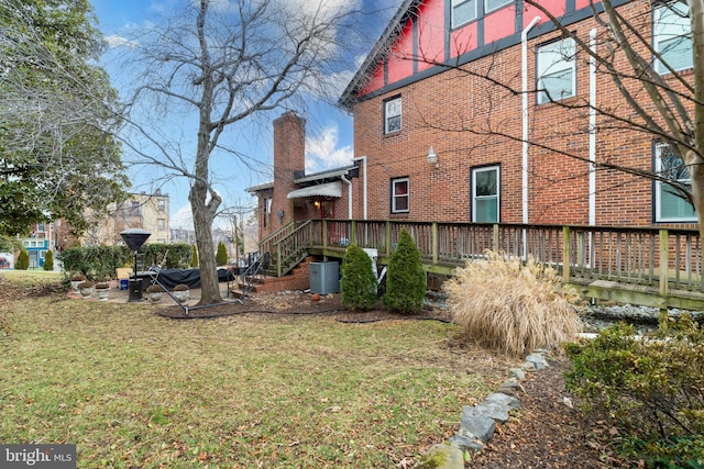 view of property exterior with a yard and a deck