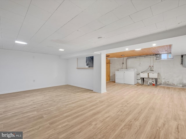 basement featuring washer and clothes dryer and light wood-type flooring