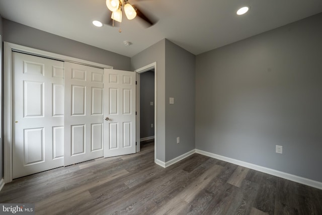 unfurnished bedroom featuring dark wood-type flooring, ceiling fan, and a closet