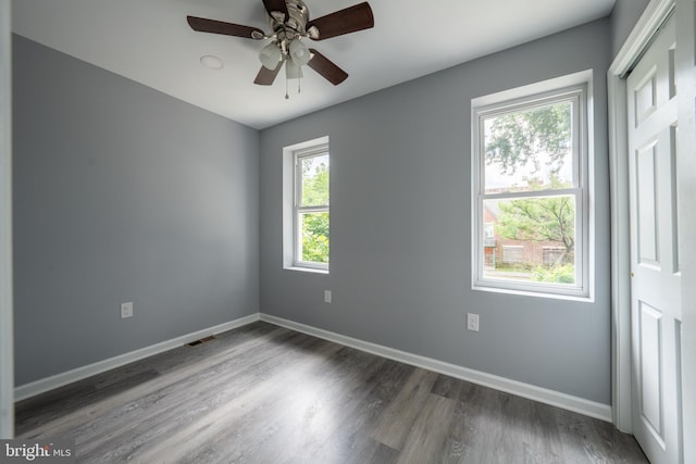 spare room with dark wood-type flooring and ceiling fan