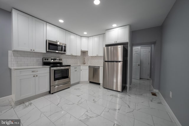 kitchen featuring white cabinetry, appliances with stainless steel finishes, and tasteful backsplash