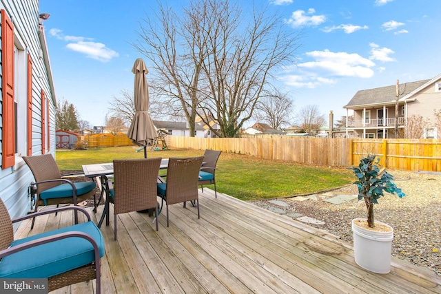 wooden deck featuring a lawn