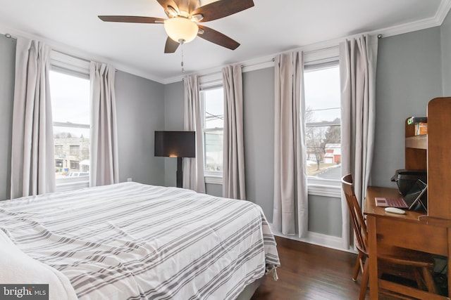 bedroom with dark wood-type flooring, ceiling fan, and crown molding