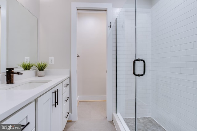 bathroom featuring tile patterned floors, a shower with door, and vanity