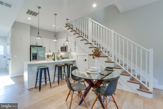 dining space featuring sink and light wood-type flooring