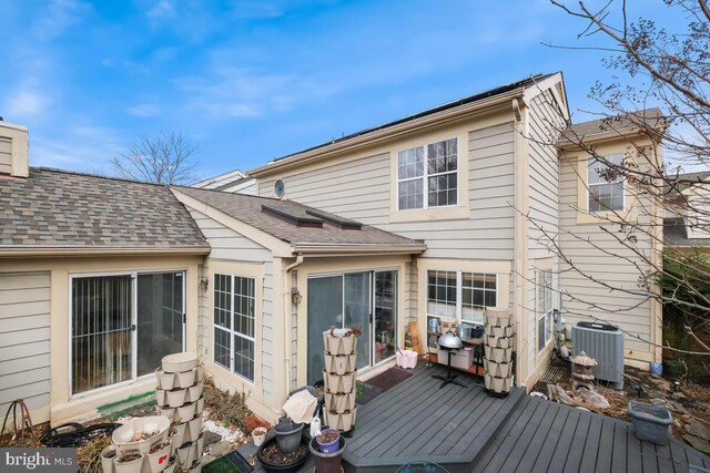 rear view of house with a wooden deck and central AC