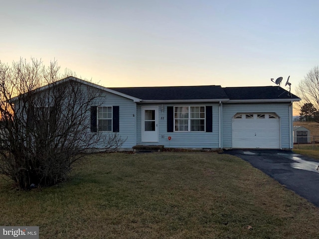 single story home featuring a garage and a yard