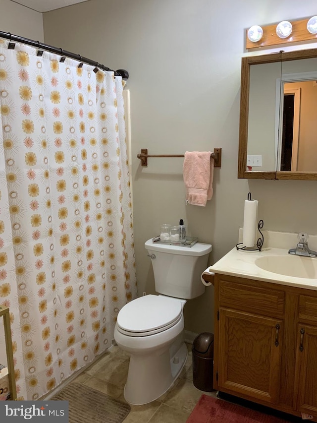 bathroom with tile patterned flooring, vanity, and toilet