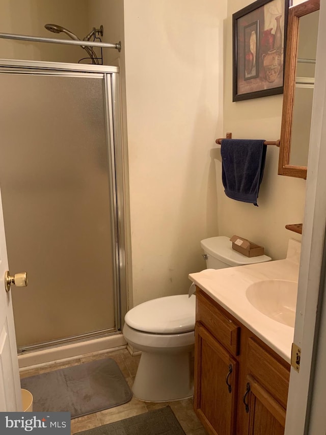 bathroom featuring vanity, tile patterned floors, toilet, and walk in shower