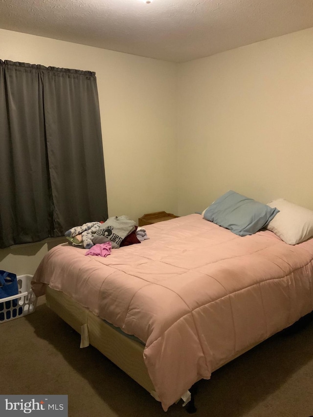 bedroom featuring carpet floors and a textured ceiling