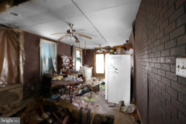 interior space with brick wall and ceiling fan