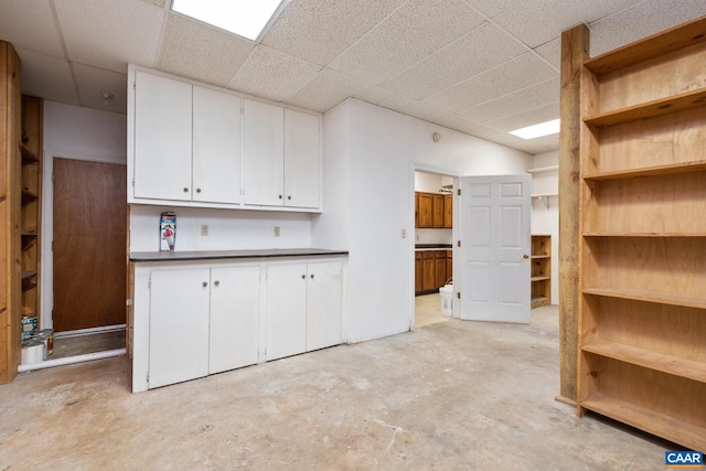 kitchen featuring white cabinetry and a drop ceiling