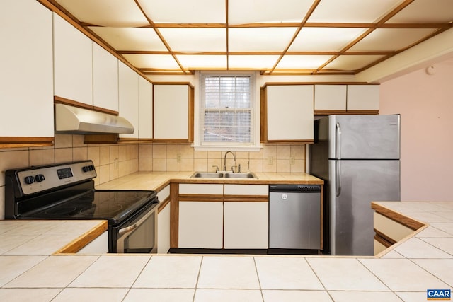 kitchen featuring sink, backsplash, white cabinets, and appliances with stainless steel finishes