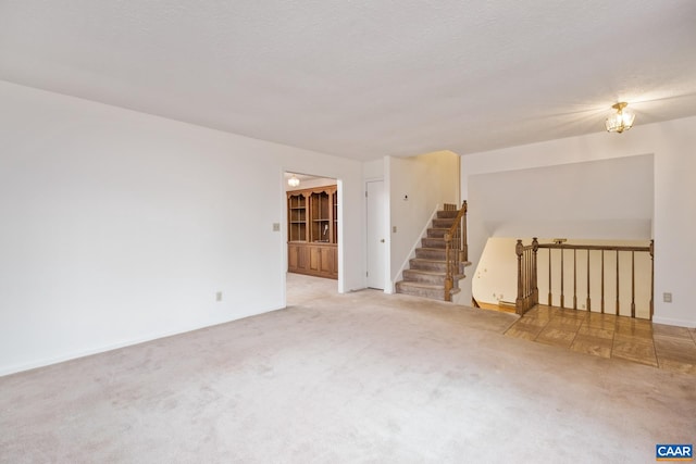 carpeted spare room with a textured ceiling