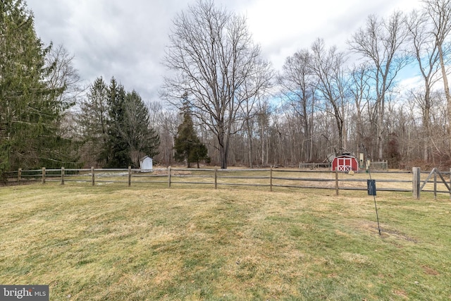 view of yard featuring a rural view and a storage shed