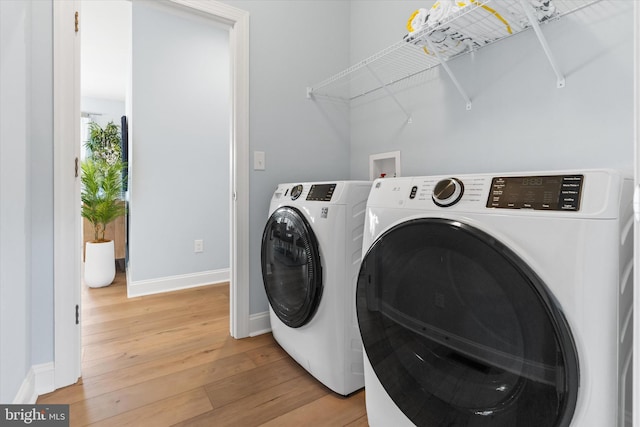 washroom with wood-type flooring and washing machine and clothes dryer