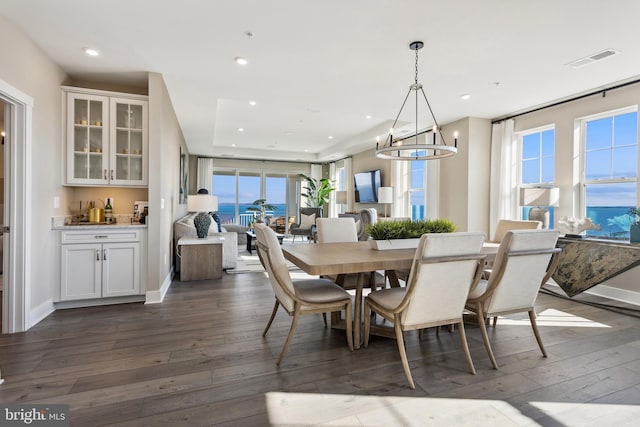 dining space featuring dark hardwood / wood-style flooring and a chandelier