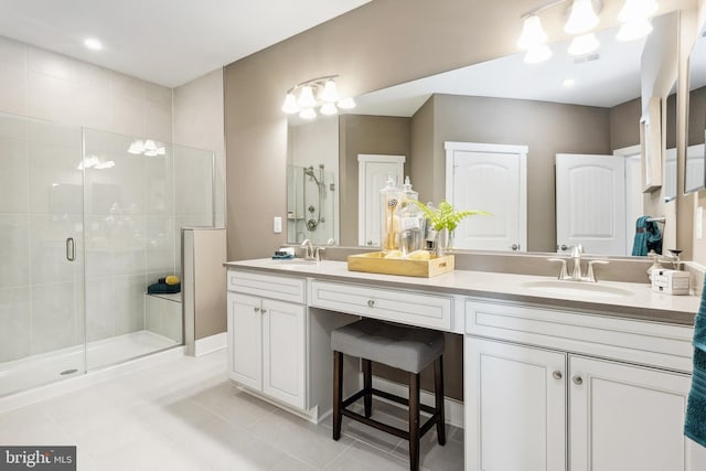 bathroom with vanity, a shower with shower door, and tile patterned floors