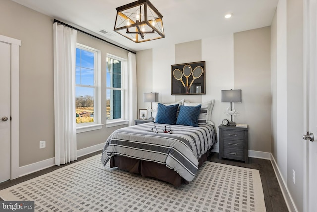 bedroom featuring dark hardwood / wood-style flooring and a chandelier