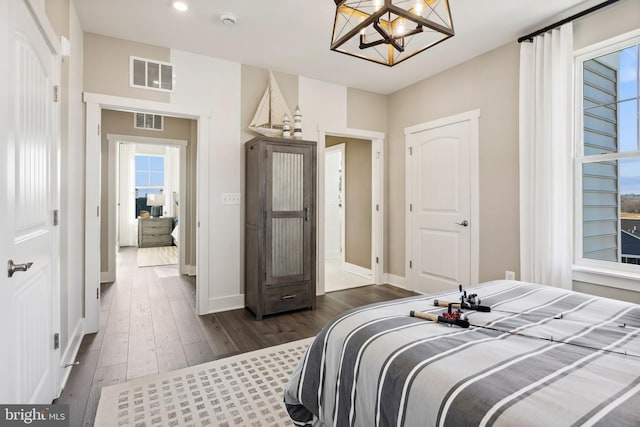 bedroom featuring dark hardwood / wood-style flooring and a notable chandelier