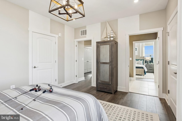 bedroom featuring dark hardwood / wood-style floors and a chandelier