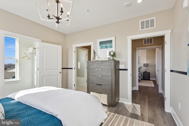 bedroom with an inviting chandelier and light hardwood / wood-style floors