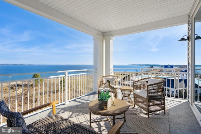 balcony with a water view and a view of the beach