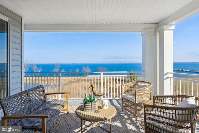 balcony featuring a water view, outdoor lounge area, and a view of the beach