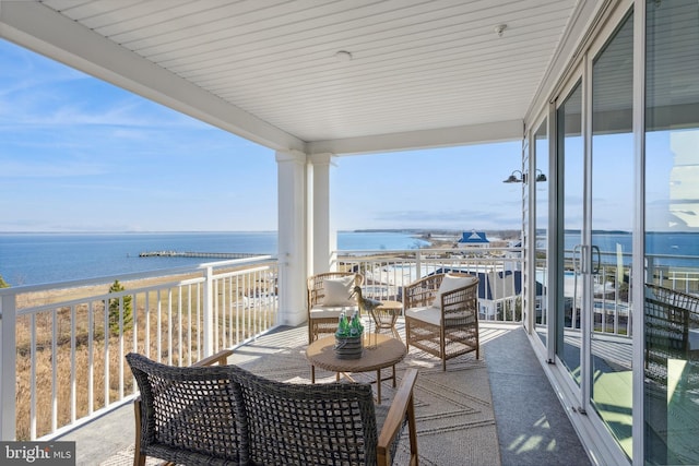 balcony with a water view and a view of the beach