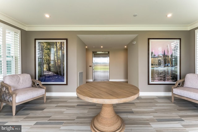 sitting room featuring ornamental molding and elevator