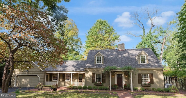 cape cod house with a garage, covered porch, and a front lawn