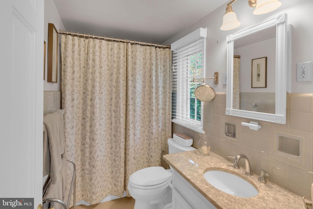 bathroom featuring vanity, toilet, and tile walls