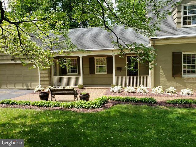 exterior space featuring a garage, covered porch, and a lawn