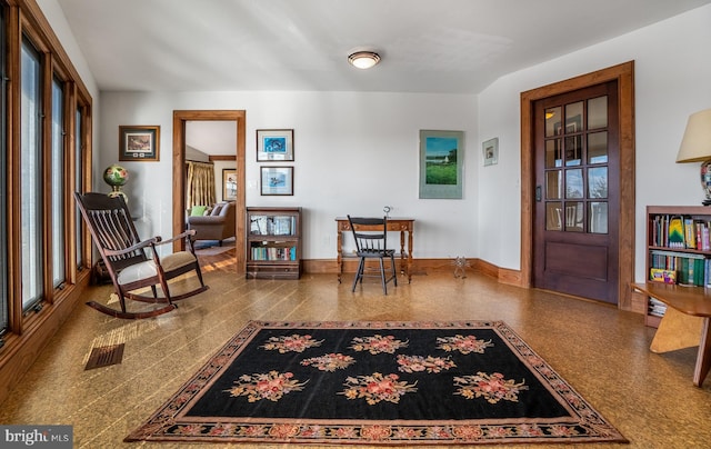 entrance foyer with a wealth of natural light, visible vents, baseboards, and speckled floor