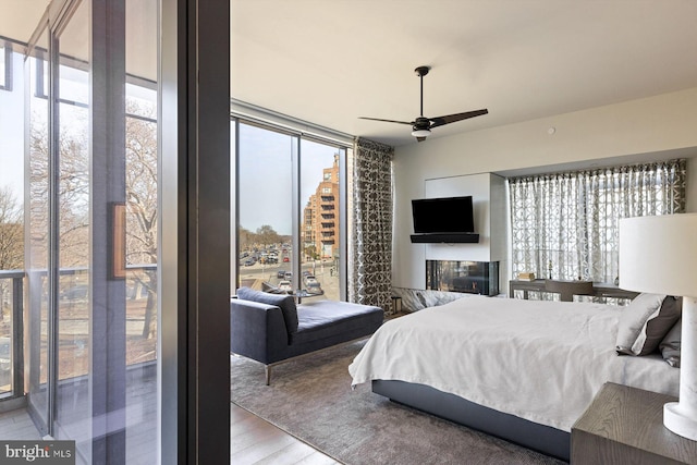 bedroom featuring hardwood / wood-style flooring, floor to ceiling windows, and a multi sided fireplace