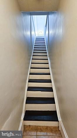 staircase with tile patterned floors