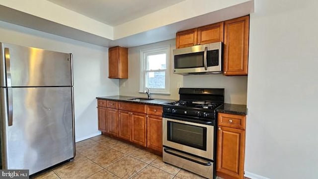 kitchen featuring appliances with stainless steel finishes, sink, and light tile patterned floors