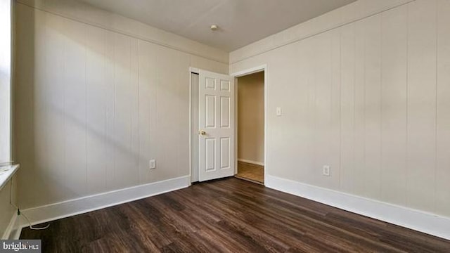 unfurnished room featuring dark wood-type flooring