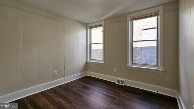 unfurnished room with dark hardwood / wood-style flooring