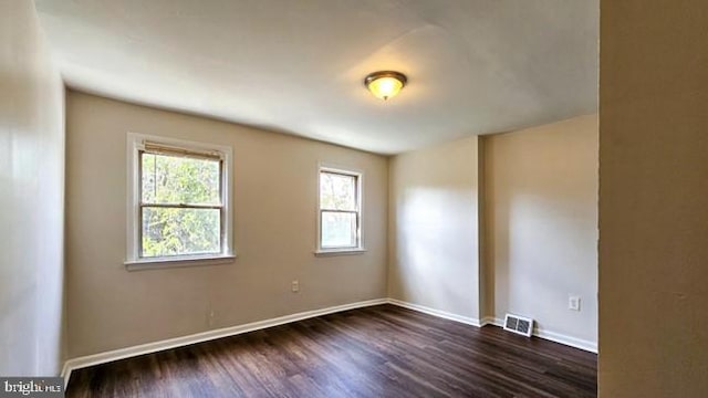 empty room with dark hardwood / wood-style floors