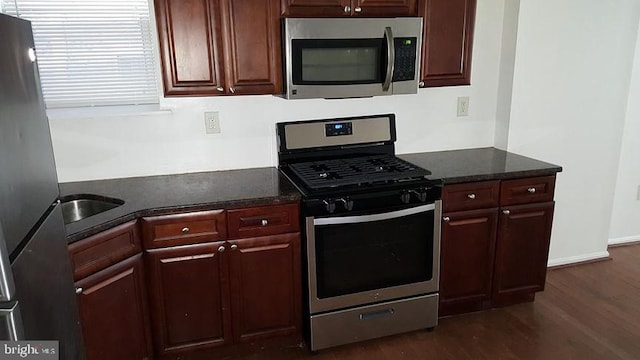 kitchen featuring appliances with stainless steel finishes, dark hardwood / wood-style flooring, and sink