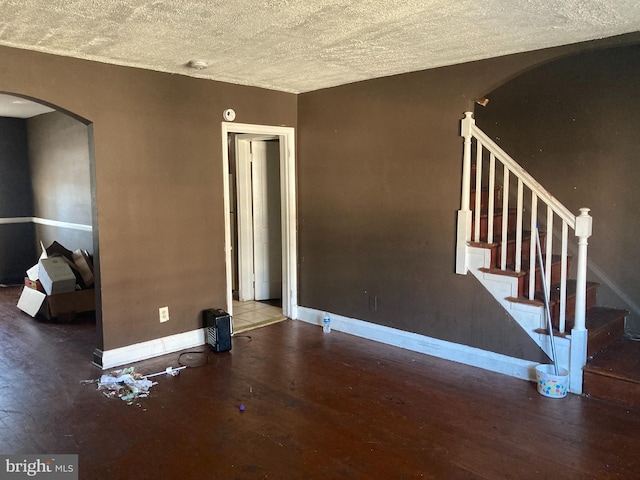 unfurnished living room featuring hardwood / wood-style floors and a textured ceiling