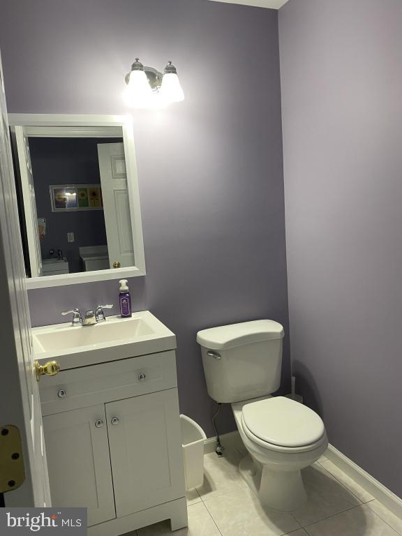 bathroom featuring tile patterned flooring, vanity, and toilet