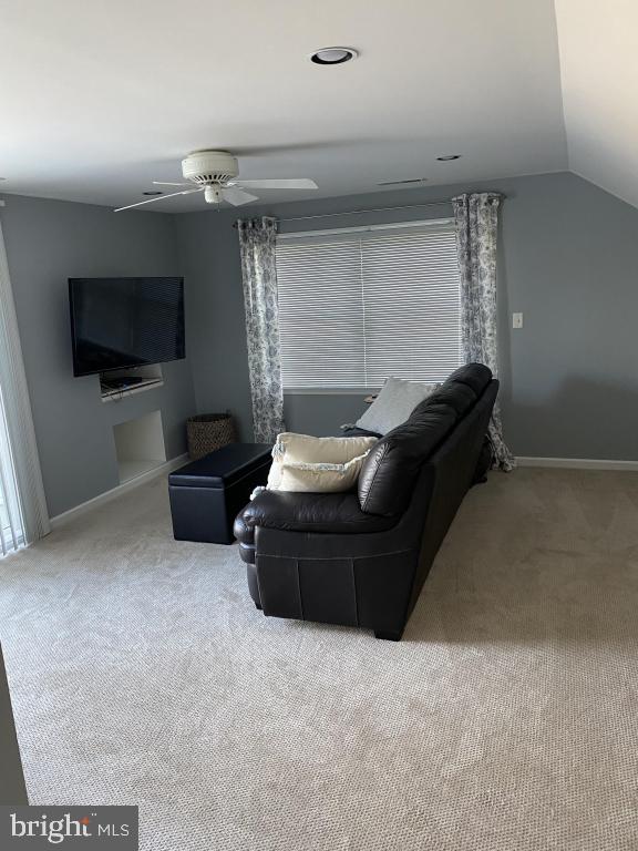 carpeted living room featuring lofted ceiling and ceiling fan