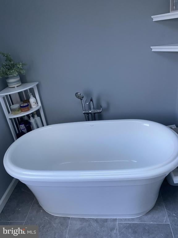 bathroom featuring tile patterned floors and a tub to relax in