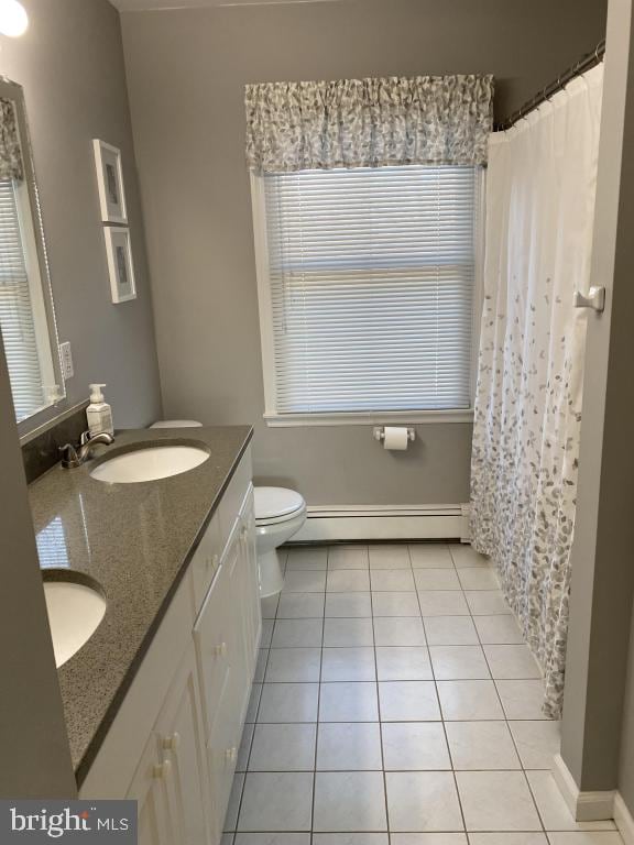 bathroom with tile patterned floors, toilet, vanity, and a baseboard heating unit