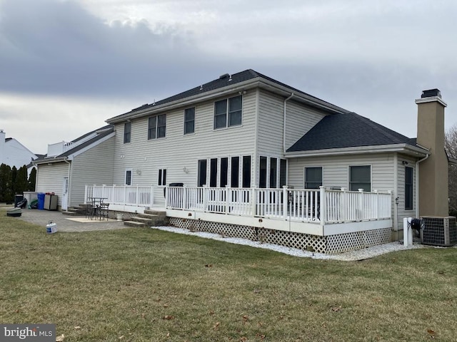 rear view of property with a wooden deck, a yard, a patio, and central air condition unit