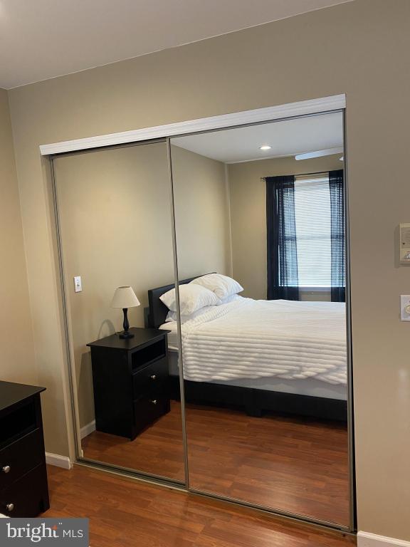 bedroom with wood-type flooring and a closet