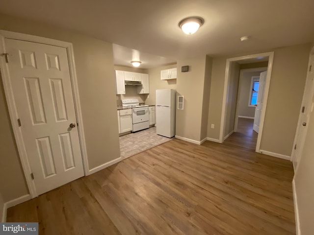 kitchen with white cabinetry, white appliances, and light wood-type flooring